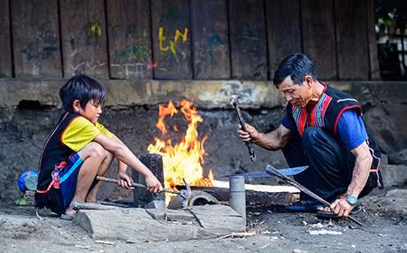 A Thiện (trái) chăm chú nhìn ông A Hình rèn