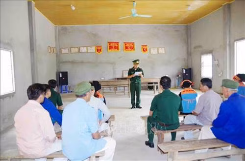 Cán bộ Đồn Biên phòng cửa khẩu Ma Lù Thàng tuyên truyền cho người dân xã Ma Ly Pho về việc thực hiện các chủ trương của Đảng, chính sách pháp luật của Nhà nước. Ảnh: Công Tuyên - TTXVN
