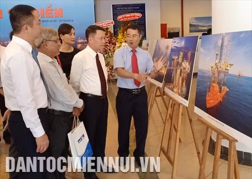 Ông Nguyễn Đức Lợi, Ủy viên Trung ương Đảng, Tổng giám đốc TTXVN (thứ hai, từ phải sang) cùng các đại biểu xem ảnh triển lãm sau nghi thức khai mạc Một số tác phẩm trưng bày tại triển lãm