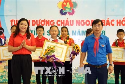 Đại diện Tỉnh đoàn Sơn La trao Bằng khen thi đua làm theo 5 điều Bác Hồ dạy cho em Đinh Thảo Ly (huyện Sốp Cộp). Ảnh: Diệp Anh - TTXVN