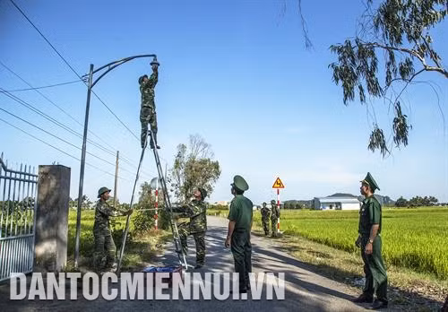 Chiến sĩ Đồn Biên phòng Cửa khẩu Quốc tế Hà Tiên lắp bóng đèn chiếu sáng. Ảnh: Việt Hồng