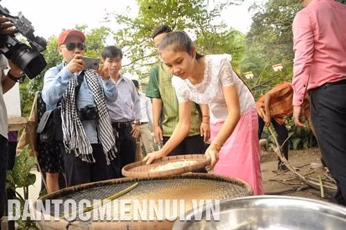 Du khách trải nghiệm, tìm hiểu cách làm cốm dẹp tại một gia đình người Khmer thuộc Làng văn hóa Khmer Nam Bộ. Ảnh: An Hiếu