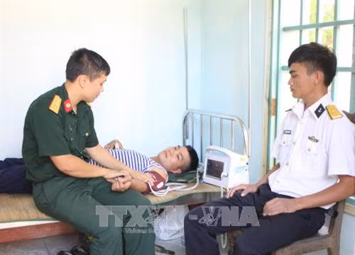 Các chiến sĩ quân y đảo Sơn Ca khám chữa bệnh cho cán bộ chiến sĩ. Ảnh: Dương Giang - TTXVN