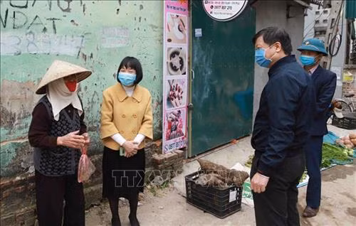 Đoàn công tác hỏi thăm sức khỏe và động viên người dân đang sinh sống tại xã Sơn Lôi. Ảnh: Hoàng Hùng - TTXVN