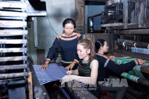 Chị H’Yam Bkrông hướng dẫn chị em buôn Tơ Jú làm sản phẩm thổ cẩm.