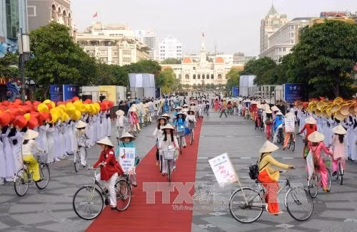 Các sinh viên diễu hành xe đạp “Năng động áo dài” tại chương trình. Ảnh: An Hiếu – TTXVN
