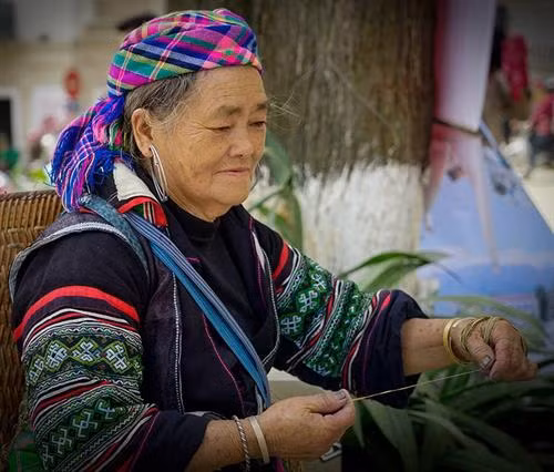 Việc đầu tiên phụ nữ Mông làm là thu hoạch cây lanh và được phơi thành những đụm to ở bất cứ khoảng đất rộng nào. Khi lanh đã đủ khô được mang về nhà, tước vỏ... …tiếp đó là giã lanh và nối sợi. Đây là công đoạn vất vả và tốn nhiều công sức nhất, sau khi giã cho mềm là tỉ mẩn nối những sợi lanh sao cho đều và đẹp. Phụ nữ Mông luôn tranh thủ trên đường lên nương, xuống chợ hay bất cứ khi nào, miễn đôi tay được "rảnh" là lại thoăn thoắt nối sợi, cuộn thành những búi nhỏ ở tay. Sau khi se và nối sợi bằng tay, sợi được đưa lên guồng se tiếp một lần nữa rồi cho vào guồng thu sợi. Qua các công đoạn sơ chế, sợi có màu trắng, mịn, dai và tiếp tục lăn mỏng, phẳng hơn, sau đó được xếp thành con chỉ dệt và dệt thành vải. Để tạo hoa văn, họa tiết, người Mông thường dùng kỹ thuật vẽ sáp ong do những người lớn tuổi có kinh nghiệm lâu năm thực hiện. Nhuộm chàm là công đoạn không thể thiếu. Sau khi nhuộm chàm, những tấm vải được phơi khô và giặt tẩy sáp... ... tiếp tục giặt nhiều lần rồi lăn để tạo độ phẳng và mịn. Những tấm vải thổ cẩm hoàn thành chứa đựng trong đó bao mồ hôi, công sức của phụ nữ Mông.