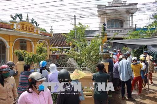 Một số người dân hiếu kỳ tụ tập bên ngoài khuôn viên chùa Ông xem vật thể lạ. Ảnh: Thanh Bình-TTXVN