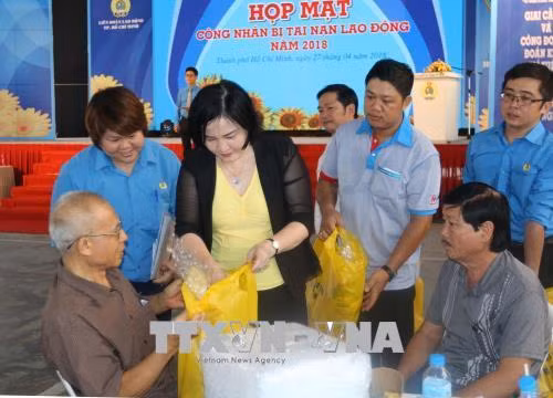 Lãnh đạo Liên đoàn Lao động Thành phố Hồ Chí Minh thăm hỏi, tặng quà công nhân bị tai nạn lao động tại buổi họp mặt. Ảnh: Thanh Vũ-TTXVN