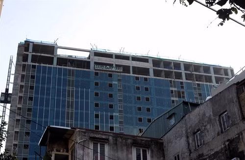 Tòa nhà 8B Lê Trực đang được tháo dỡ phần vi phạm nhưng tiến độ rất chậm. Ảnh: Tuấn Anh- TTXVN