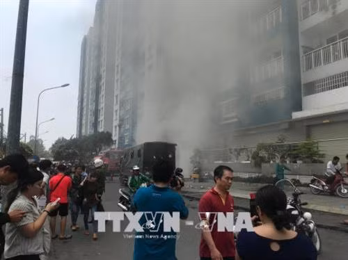 Khói bất ngờ bùng phát trở lại tại khu vực hầm để xe của chung cư Carina. Ảnh: Thành Chung - TTXVN