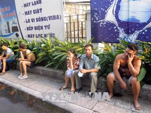 Người dân rời khỏi hiện trường vụ cháy thoát ra ngoài. Ảnh: Hoàng Hải-TTXVN