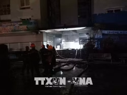 Cảnh sát PCCC phun nước dập tắt đám cháy phát ra từ tầng hầm chung cư. Ảnh: Thành Chung - TTXVN