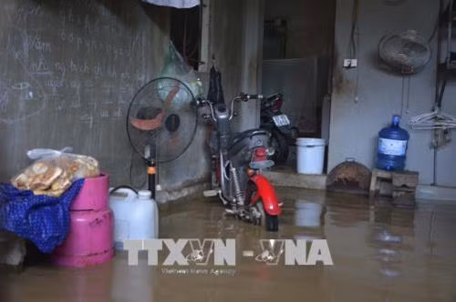 Nước ngập vào nhà nhiều hộ dân. Ảnh: Xuân Tư - TTXVN