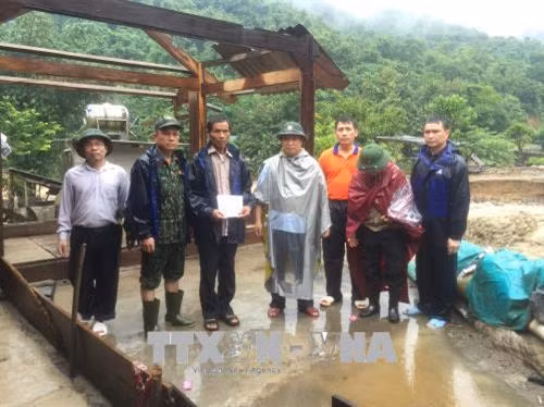 Phó Bí thư Huyện ủy huyện Kỳ Sơn Lỳ Bá Thái thăm hỏi, động viên gia đình bị thiệt hại do mưa lũ gây ra. Ảnh: Duy Khánh - TTXVN