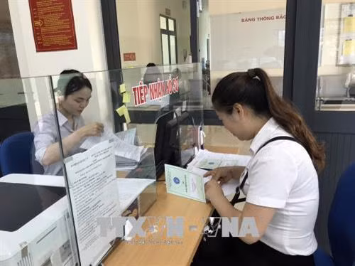 Nhân viên bưu điện nhận sổ bảo hiểm từ cơ quan bảo hiểm xã hội tỉnh Sơn La để bàn giao cho người lao động. Ảnh: Hữu Quyết - TTXVN