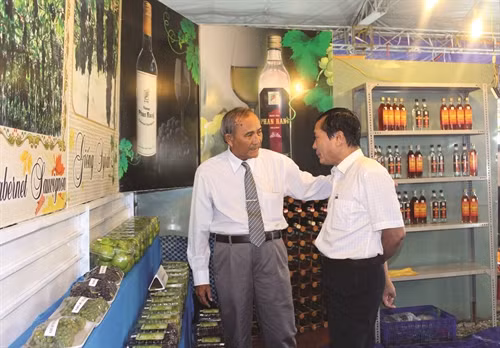Ông Ba Mọi giới thiệu sản phẩm nho với khách hàng.