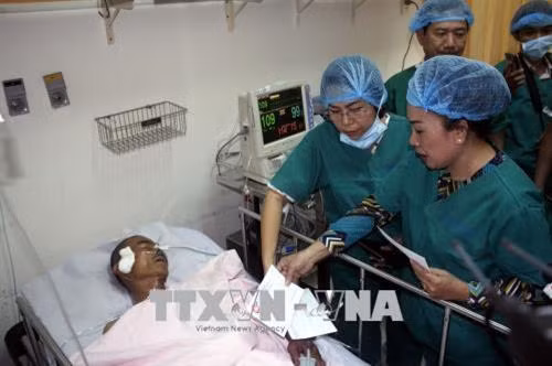 Lãnh đạo thành phố tặng quà cho anh Trần Văn Hoàng, Đội trưởng Đội "hiệp sĩ đường phố" quận Tân Bình, đang điều trị tại Bệnh viện 115. Ảnh: Hoàng Hải - TTXVN
