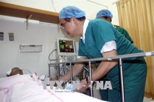 Bí thư Thành ủy Nguyễn Thiện Nhân thăm anh Trần Văn Hoàng, Đội trưởng Đội "hiệp sĩ đường phố" quận Tân Bình, đang điều trị tại Bệnh viện 115. Ảnh: Hoàng Hải - TTXVN