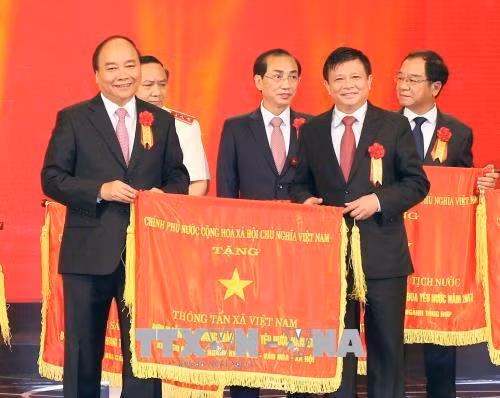 Thủ tướng Nguyễn Xuân Phúc tặng cờ thi đua của Chính phủ cho Thông tấn xã Việt Nam, đơn vị dẫn đầu phong trào thi đua yêu nước năm 2017. Ảnh: Doãn Tấn - TTXVN.