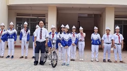 Tặng xe đạp cho học sinh khó khăn, khuyết tật từ nguồn tiền bán rau do đội viên trồng. Ảnh: Hồng Điệp – TTXVN