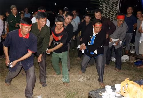 Những thành viên ngồi làm lễ dưới sự chủ trì của một Thầy Tào có uy tín trong vùng. Ảnh: Văn Tý-TTXVN
