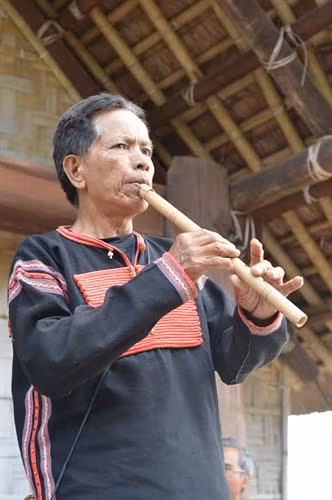 Nghệ nhân Y'mip Ayun với nhạc cụ thổi bằng ống nứa của dân tộc Ê Đê