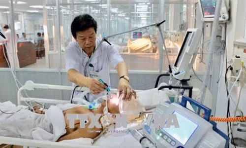 Thiếu tướng Nguyễn Hồng Sơn, Giám đốc Bệnh viện Quân y 175 trực tiếp kiểm tra cho bệnh nhân được đưa về đất liền bằng trực thăng. Ảnh: TTXVN phát