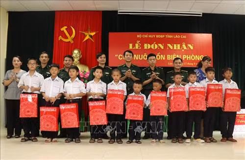 Tặng quà cho các cháu được các Đồn biên phòng ở Lào Cai nhận nuôi dưỡng tại đồn. Ảnh: Quốc Khánh - TTXVN