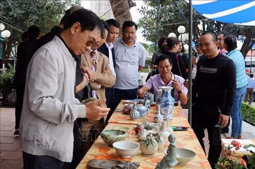 Du khách tham quan các gian hàng trưng bày cổ vật ở chợ Tết “Một thoáng thành Nam” tại Bảo tàng tỉnh Nam Định. Ảnh: Nguyễn Lành - TTXVN