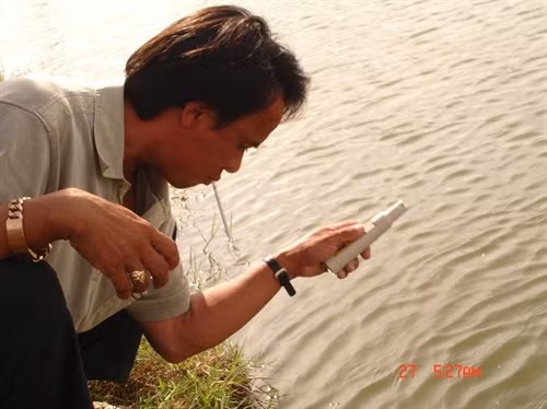 Anh Bùi Xuân Tương, chủ trang trai đang kiềm tra độ phèn ao nuôi cá chình
