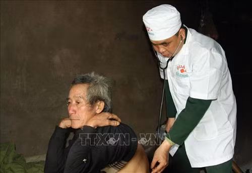 Trung úy Văn Trung Kiên, quân y Đồn biên phòng Tùng Vài, thăm khám cho ông Giàng Vần Sìn, thôn Pao Mả Phìn, xã Tùng Vài, huyện Quản Bạ (Hà Giang). Ảnh: Nguyễn Chiến - TTXVN