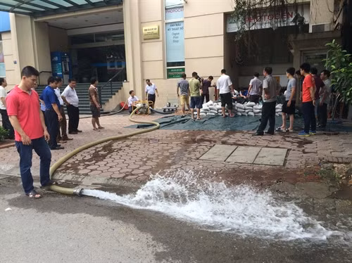 Diễn tập phương án đắp bao cát hàn khẩu chống ngập trong trong trường hợp mưa to nước tràn vào tầng hầm toà nhà. Ảnh: Hải Anh- TTXVN
