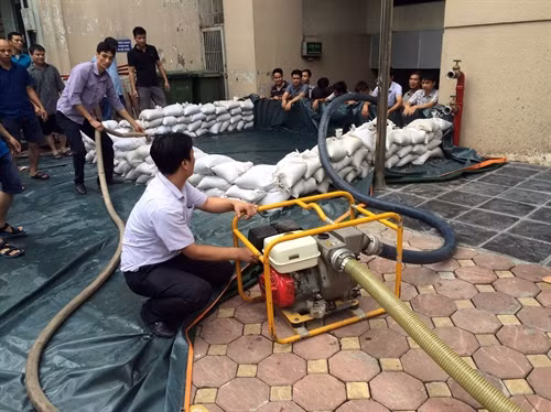 Diễn tập phương án đắp bao cát hàn khẩu chống ngập trong trong trường hợp mưa to nước tràn vào tầng hầm toà nhà. Ảnh: Hải Anh- TTXVN