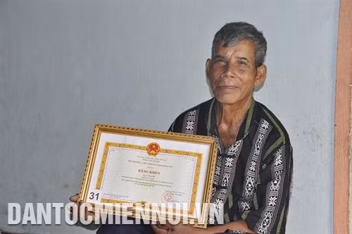 Già làng A Nguyh vinh dự được Bộ trưởng, Chủ nhiệm Ủy ban Dân tộc Đỗ Văn Chiến trao tặng Bằng khen vì đã có thành tích tiêu biểu thực hiện Quyết tâm thư của Già làng các dân tộc khu vực Tây Nguyên năm 2019. Ảnh: Văn Phương
