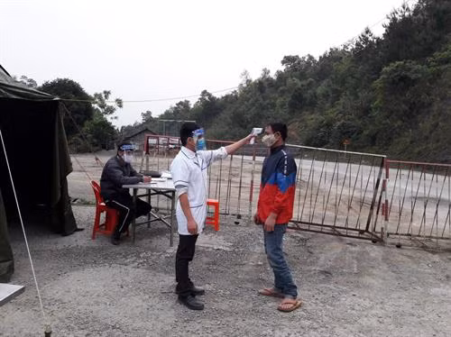 Nhân viên y tế huyện Ngân Sơn (Bắc Kạn) kiểm tra thân nhiệt người dân đi qua chốt kiểm dịch khu vực đèo Cao Bắc. Ảnh: baobackan.org.vn