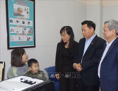 Bí thư Tỉnh ủy Bắc Ninh Nguyễn Nhân Chiến (thứ 2 từ phải sang) và các đại biểu thăm hỏi, động viên người dân đưa con đi xét nghiệm tại Bệnh viện Sốt rét, Ký sinh trùng, Côn trùng Trung ương. Ảnh: Thanh Thương – TTXVN