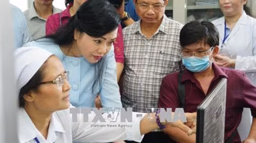 Bộ trưởng Nguyễn Thị Kim Tiến kiểm tra phần mềm điện tử quản lý điều trị ARV tại quận Gò Vấp. Ảnh: Đinh Hằng - TTXVN