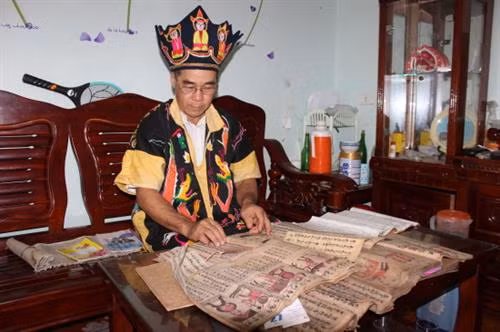 Ông Nịnh Văn Chau sưu tầm, biên soạn chữ của người Cao Lan sang tiếng Việt để dạy cho các em trong thôn, xã. Ảnh: Long Vũ