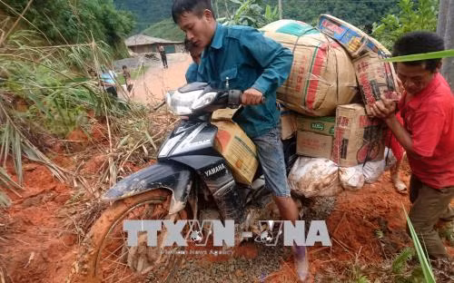 Người dân nỗ lực vận chuyển nhu yếu phẩm vào Pa Vệ Sủ. Ảnh: Việt Hoàng - TTXVN