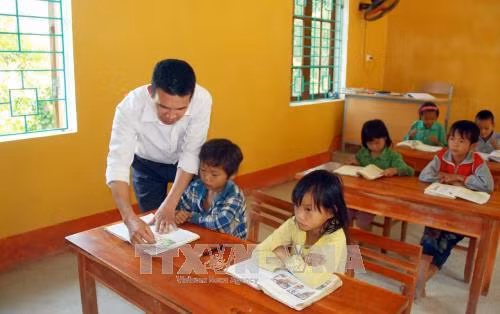Thầy Nguyễn Trọng Tài với học sinh điểm trường Cọ Cỏm. Ảnh: Quang Cường – TTXVN