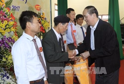 Chủ tịch nước Trần Đại Quang tặng quà cho các cá nhân có thành tích xuất sắc trong công tác đại đoàn kết toàn dân tộc. Ảnh: Nhan Sáng -TTXVN