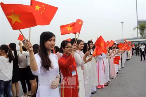 Các thiếu nữ Thủ đô nồng nhiệt chào mừng Tổng Bí thư, Chủ tịch Trung Quốc Tập Cận Bình tại Lễ đón ở Sân bay Quốc tế Nội Bài, Hà Nội. Ảnh: Trần Việt - TTXVN