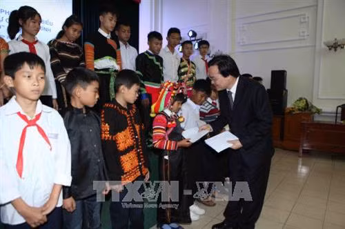 Bộ trưởng Bộ Giáo dục và Đào tạo Phùng Xuân Nhạ hỏi thăm, tặng quà cho các em học sinh có hoàn cảnh đặc biệt khó khăn được đỡ đầu trong Chương trình “Chiến sĩ quân hàm xanh nâng bước em tới trường”. Ảnh: Quý Trung – TTXVN