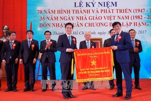Thứ trưởng Bộ Y tế Nguyễn Thanh Long trao Cờ của Chính phủ cho Trường Đại học Y Dược Thành phố Hồ Chí Minh. Ảnh: Phương Vy-TTXVN