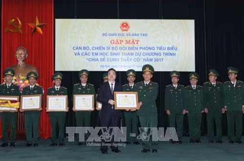 Bộ trưởng Bộ Giáo dục và Đào tạo Phùng Xuân Nhạ tặng Bằng khen cho 60 cán bộ, chiến sĩ Bộ đội Biên phòng tiêu biểu có nhiều đóng góp cho sự nghiệp giáo dục năm 2017. Ảnh: Quý Trung – TTXVN