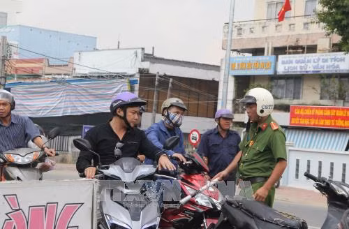 Lực lượng chức năng hướng dẫn người dân lưu thông theo hướng khác. Ảnh: Bùi Như Trường Giang - TTXVN