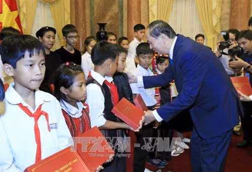 Chủ tịch nước Trần Đại Quang tặng quà cho các học sinh dân tộc thiểu số. Ảnh: Nhan Sáng – TTXVN