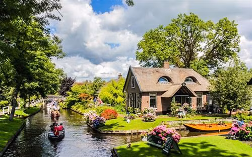 Nằm tại Lisse, một thị trấn nhỏ ở phía nam thủ đô Amsterdam, công viên Keukennhof còn được biết đến là "vườn châu Âu". Đây là vườn hoa lớn nhất thế giới với diện tích khoảng 32 ha và bảy triệu bông hoa tuy-líp thuộc 100 giống khác nhau. Ảnh: nhandan.com.vn Nằm tại Lisse, một thị trấn nhỏ ở phía nam thủ đô Amsterdam, công viên Keukennhof còn được biết đến là "vườn châu Âu". Đây là vườn hoa lớn nhất thế giới với diện tích khoảng 32 ha và bảy triệu bông hoa tuy-líp thuộc 100 giống khác nhau Đối với mỗi người dân Hà Lan, cối xay gió đã tạo nên đất nước của họ. Đây là niềm tự hào không gì sánh nổi và Kinderdijk là một trong những nơi lưu giữ tốt nhất của niềm tự hào ấy. Người ta gọi Kinderdijk là ngôi làng cối xay gió, bởi nơi đây tập hợp các cối xay gió mang nhiều giá trị lịch sử nhất tại Hà Lan. Hệ thống cối xay gió của làng Kinderdijk được UNESCO công nhận là di sản thế giới vào năm 1997.. Ảnh: nhandan.com.vn Cách Amsterdam khoảng 20 km, làng Zaanse Schans là một quần thể văn hóa gồm nhiều cối xay gió cổ và những bảo tàng lưu giữ các nét văn hóa truyền thống của người Hà Lan.. Ảnh: nhandan.com.vn Cung điện Hoàng gia tại Amsterdam vô cùng cổ kính, nguy nga và tráng lệ. Công trình này bảo tồn nhiều di sản quý giá và những tác phẩm điêu khắc bậc thầy của Hà Lan. Ảnh: nhandan.com.vn Làng Giethoorn không hề có một con đường nào, phương tiện chủ yếu để di chuyển là thuyền. Hàng trăm cây cầu bắc qua các tuyến đường thủy, kết nối những ngôi nhà với nhau, các kênh rạch cũng dẫn đến phòng trưng bày nghệ thuật và cửa hàng lưu niệm.. Ảnh: nhandan.com.vn Những ngôi nhà sắc màu trên hồ Reitdiephaven ở TP Groningen từ lâu đã trở thành một trong những điểm đến hút khách nhất tại Hà Lan, đặc biệt là đối tượng giới trẻ. Ảnh: nhandan.com.vn Bộ trang phục của phụ nữ Hà Lan xuất hiện trong chương trình quảng cáo Sữa cô gái Hà Lan gắn liền với tuổi thơ của không ít thế hệ người Việt Nam. Khi nói đến trang phục của người Hà Lan, không thể bỏ qua những đôi giày gỗ xinh xắn. Nguồn gốc của những đôi giày gỗ (hay guốc gỗ) xuất phát từ việc phần lớn đất liền Hà Lan đều nằm ngang hoặc thấp hơn mực nước biển cho nên đất nông nghiệp thường bị ngập úng, vào mùa đông thì nước ứ đọng sẽ bị đóng băng. Do đó, người Hà Lan nảy ra ý tưởng sáng chế những đôi giày gỗ giúp di chuyển dễ dàng, giữ chân khô ráo, đặc biệt là mùa đông thì ấm, mùa hè thì mát, thậm chí vào ngày đông khi trời quá lạnh người dùng có thể lót thêm rơm vào giày cho ấm và êm chân. Đôi giày gỗ cũng giúp những người vắt sữa bò bảo vệ đôi chân của họ không bị bò giẫm lên.... Ảnh: nhandan.com.vn Người hâm mộ Hà Lan mặc trang phục của đội tuyển bóng đá quốc gia "Cơn lốc mầu da cam". Ảnh: nhandan.com.vn Ở Hà Lan có đầy đủ phương tiện giao thông hiện đại nhưng xe đạp vẫn là sự lựa chọn phổ biến nhất. Những chiếc xe đạp xuất hiện trên đường phố Hà Lan tạo nên một không gian thanh bình và thư thả. Đạp xe đi khám phá những ngóc ngách của đất nước này chắc chắn sẽ là trải nghiệm khó quên đối với du khách.. Ảnh: nhandan.com.vn
