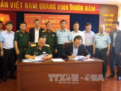 Đại diện Lãnh đạo Bộ Quốc phòng và Bộ Giao thông Vận tải ký kết biên bản. Ảnh: Hoàng Hải-TTXVN